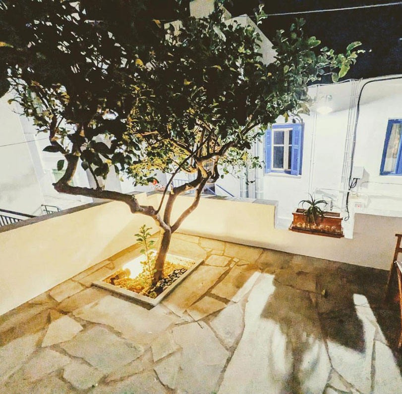 Cour pavée avec des arbres dans les chambres du Steno à Sifnos